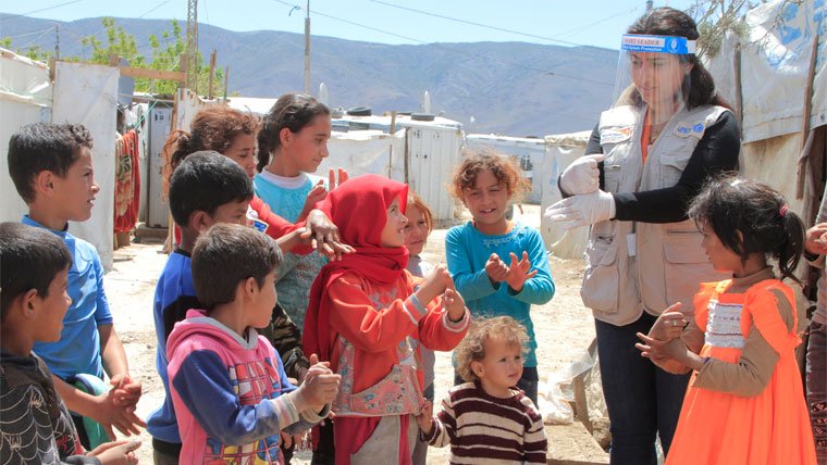 World Vision staff show children in a refugee camp how to stay safe from COVID-19
