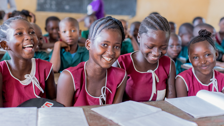 Isata sits with her friends in the classroom