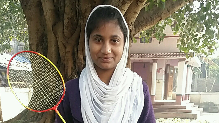 Sponsored child, Sama, holds her badminton racket