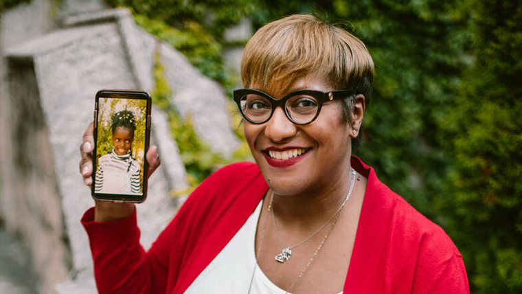 Renee proudly shows a recent photo of her sponsored child, Maureen, on her mobile phone